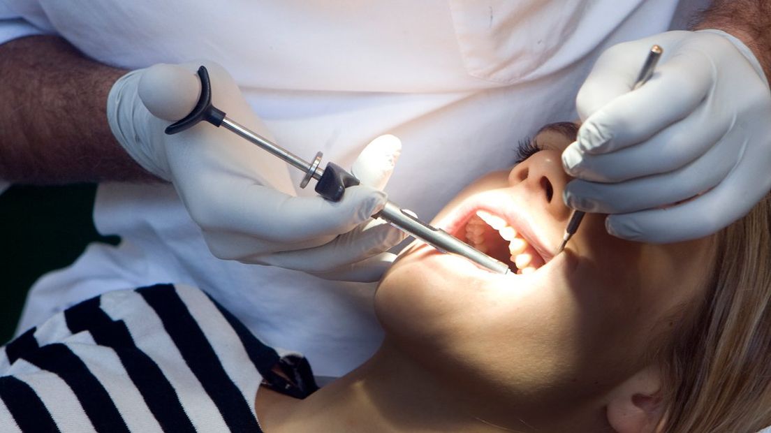 Een tandarts behandelt een patiënt. | Archief