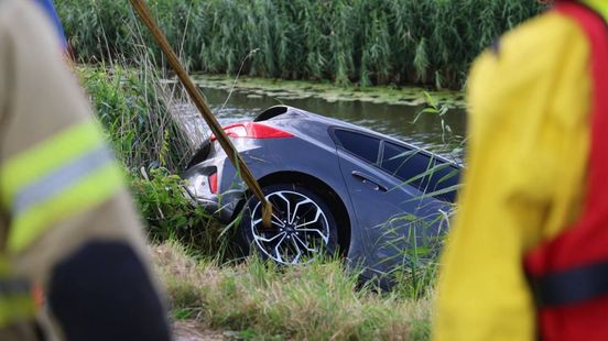 Bestuurder wacht op dak van zijn auto op hulp
