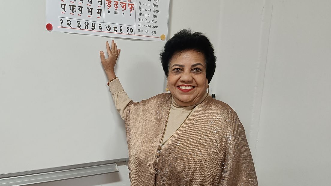 Rita Poetoe staat voor haar whiteboard in de klas