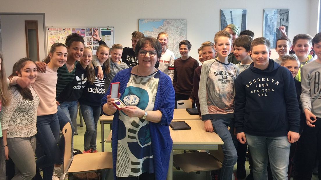 Els Mulder-van Franeker toont haar onderscheiding in de klas. 