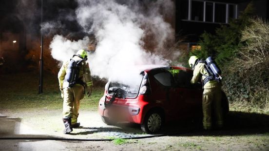 Brandweerlieden blussen vuur op achterbank van auto