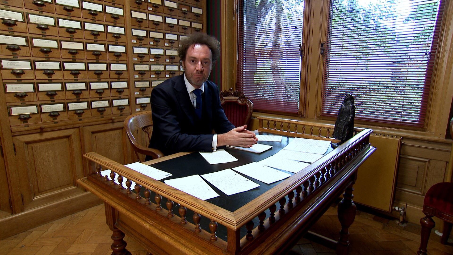 Ridder René leest de kinderbrieven in de bibliotheek van de Koninklijke Verzamelingen