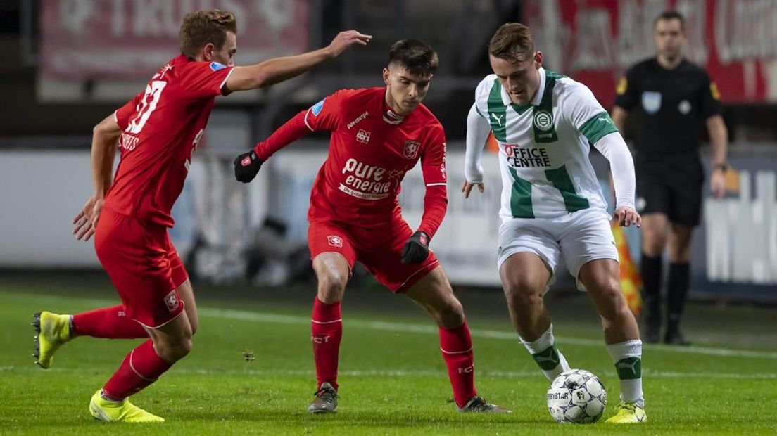 Kaj Sierhuis houdt namens FC Groningen twee verdedigers van FC Twente bezig