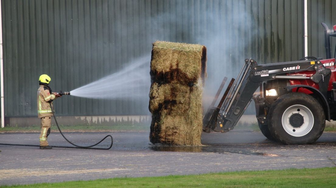 Brandweer blust vuur in balen hooi bij een landbouwschuur aan de Slikweg in Kerkwerve