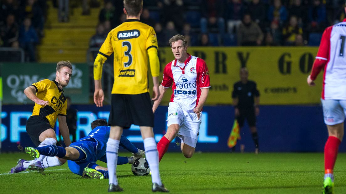 Rogier Krohne komt net te laat. NAC-doelman Brondeel heeft de bal