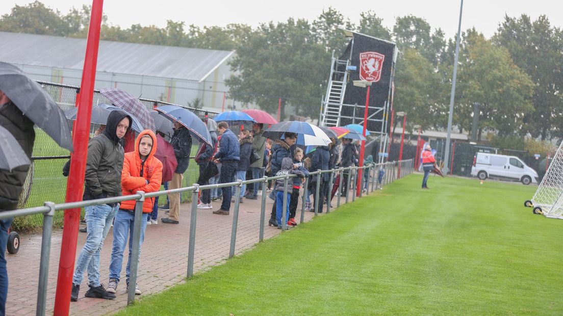Fans in de regen langs het trainingsveld in Hengelo