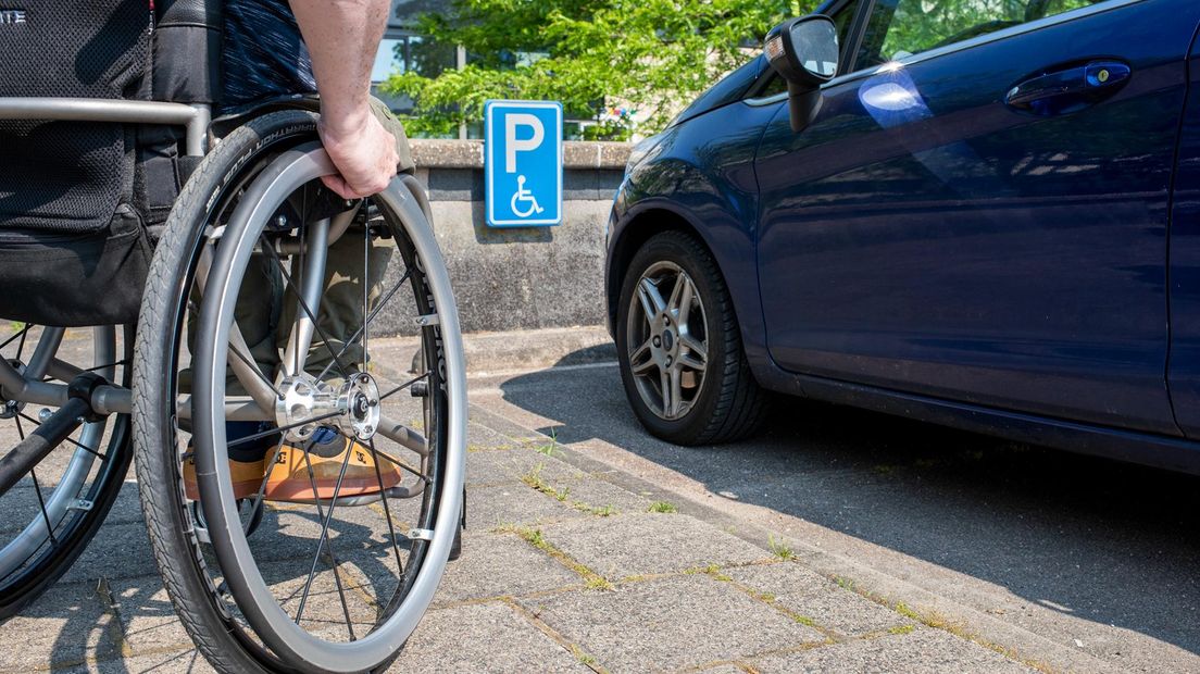 Een rolstoeler maakt gebruik van een gehandicaptenparkeerplaats