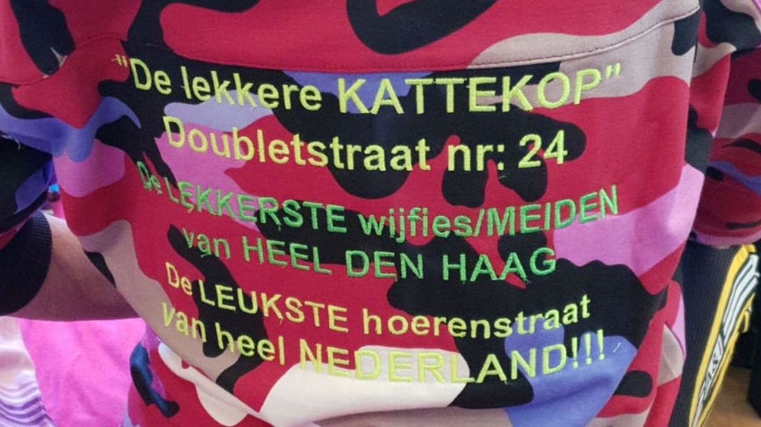 De achterkant van het trainingspak vermeldt trots wie de sponsor is