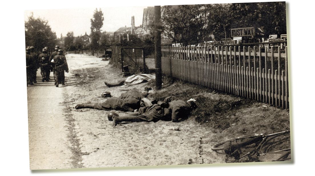 Gesneuvelde Nederlandse militairen langs de Grebbeweg in Rhenen, links marcheren de Duitsers.