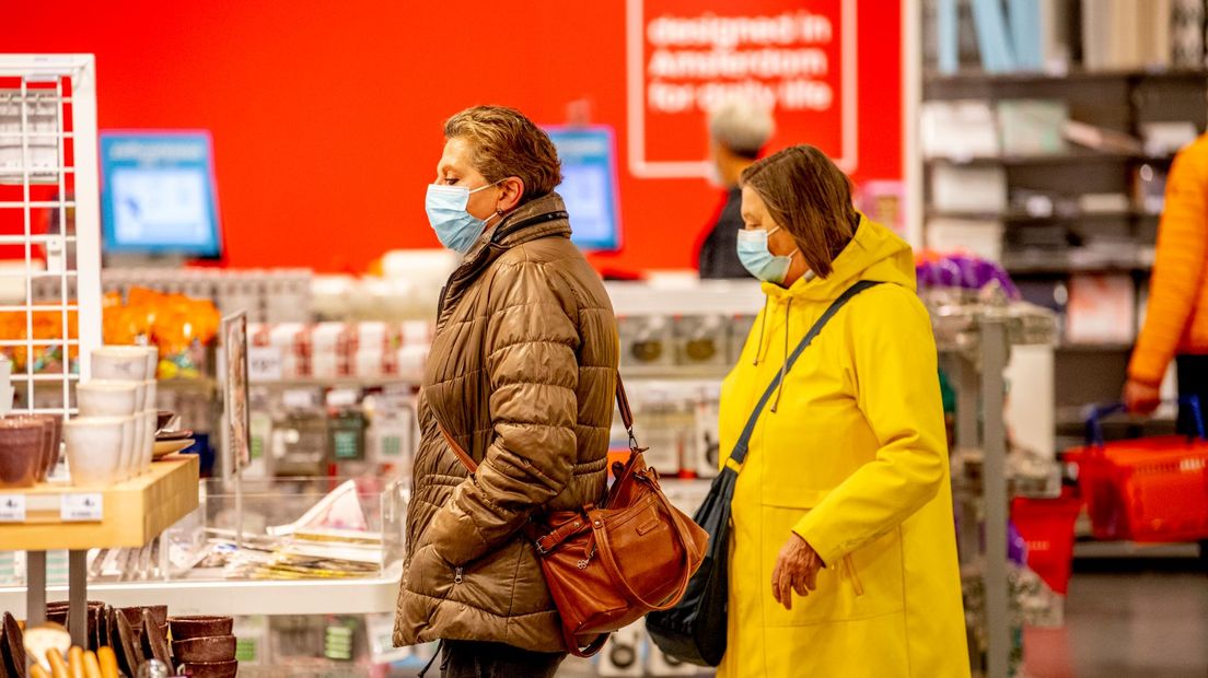 Klanten zijn aan het winkelen in de stad met een mondkapje op door de mondkapjesplicht