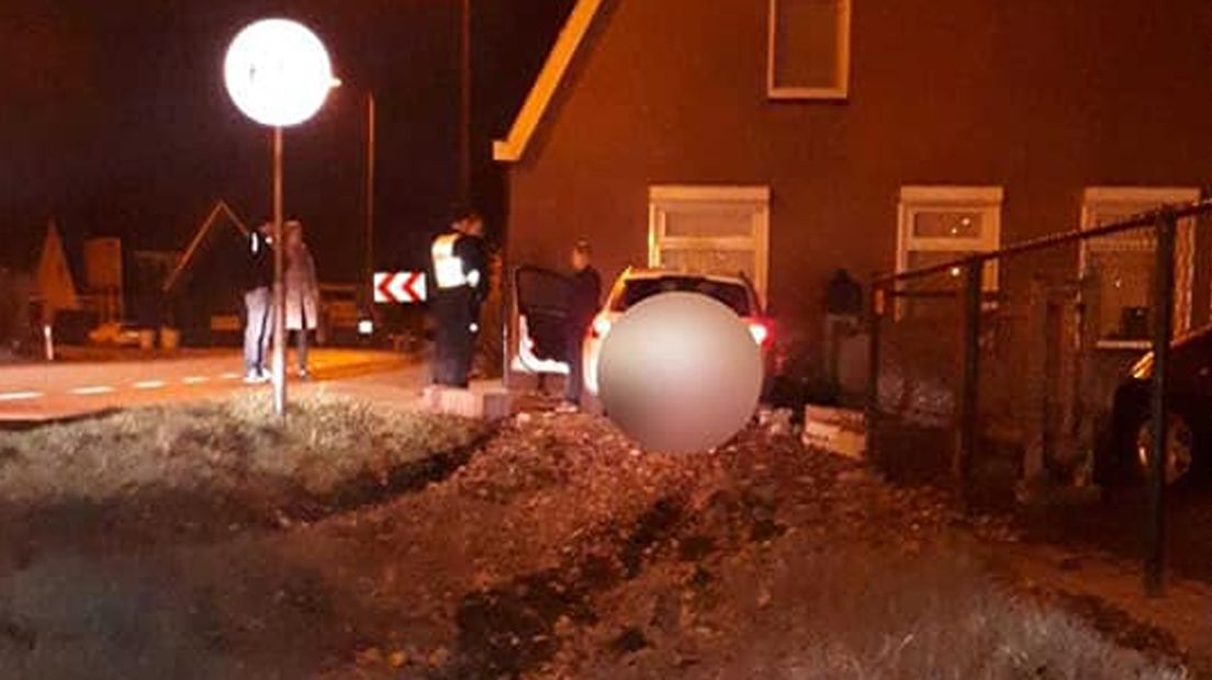 De auto reed een droge sloot in en crashte vervolgens tegen de gevel van de woning.