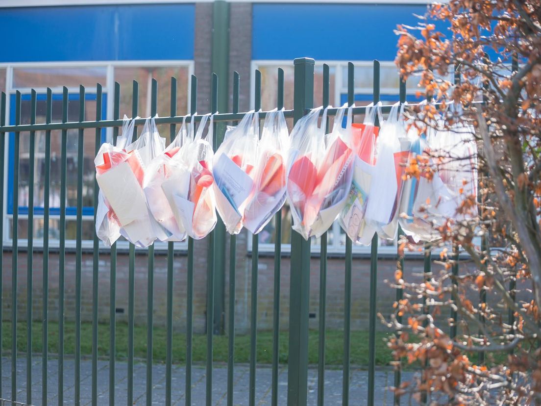 Knutselpakketjes aan het schoolhek en toch even zwaaien naar de juf