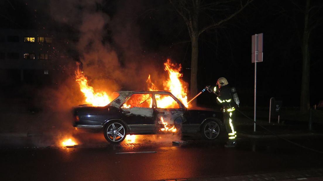 De brandende auto op de Trekweg in Den Haag tijdens het blussen
