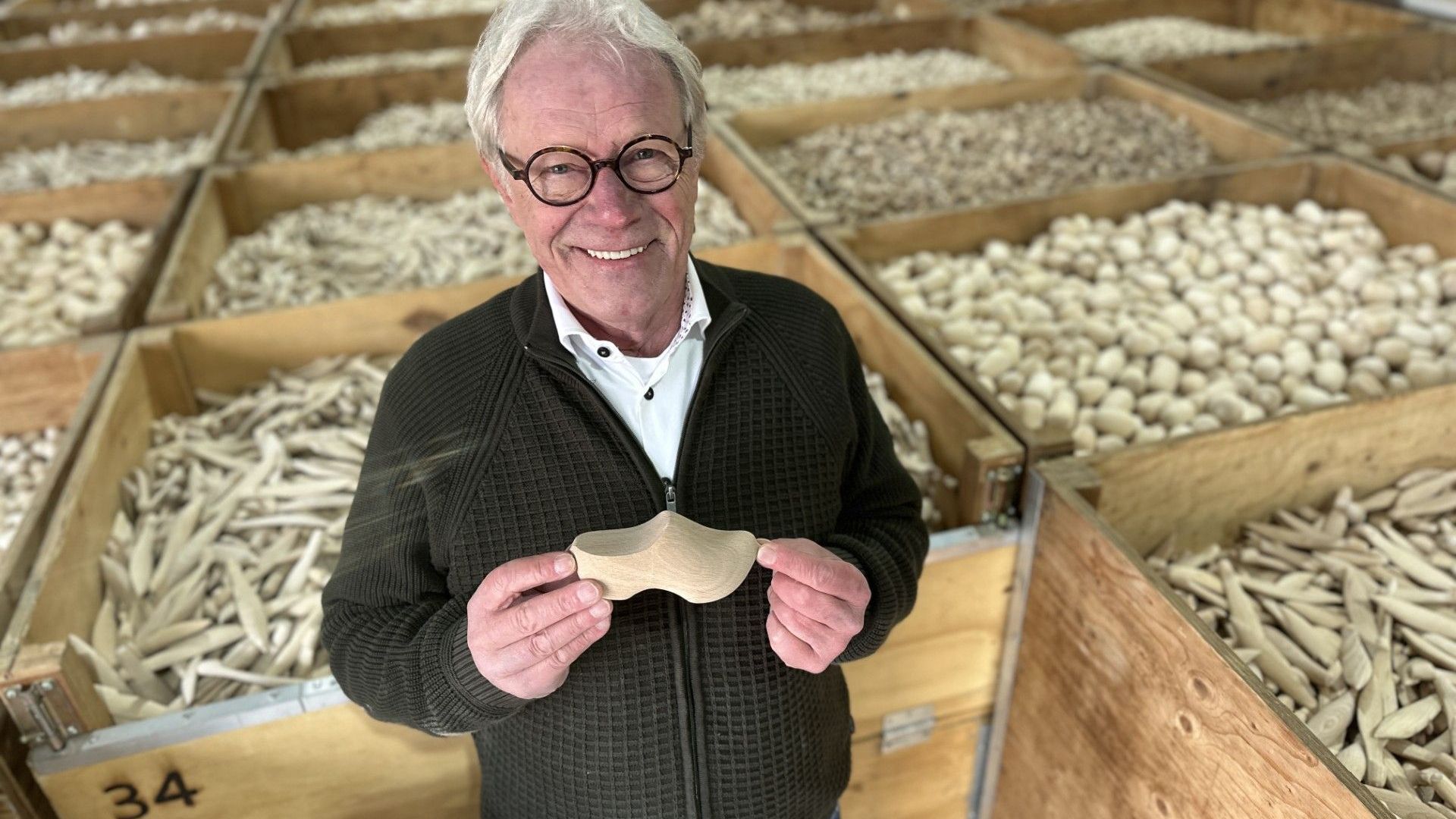 Paul Nijhuis in zijn klompenfabriek tussen de kisten met houten souvenirs