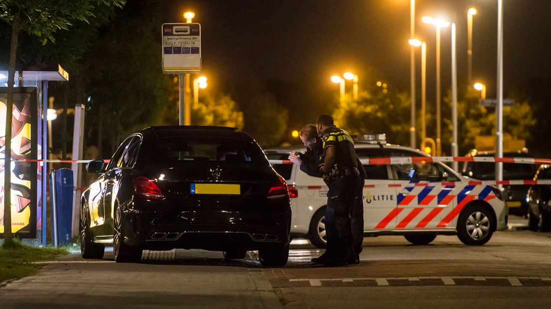 Tussen de afzetlinten staat een zwarte Mercedes.