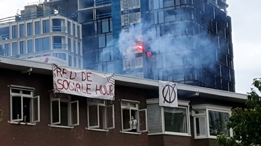 Een kraker op het dak van de sloopwoningen.