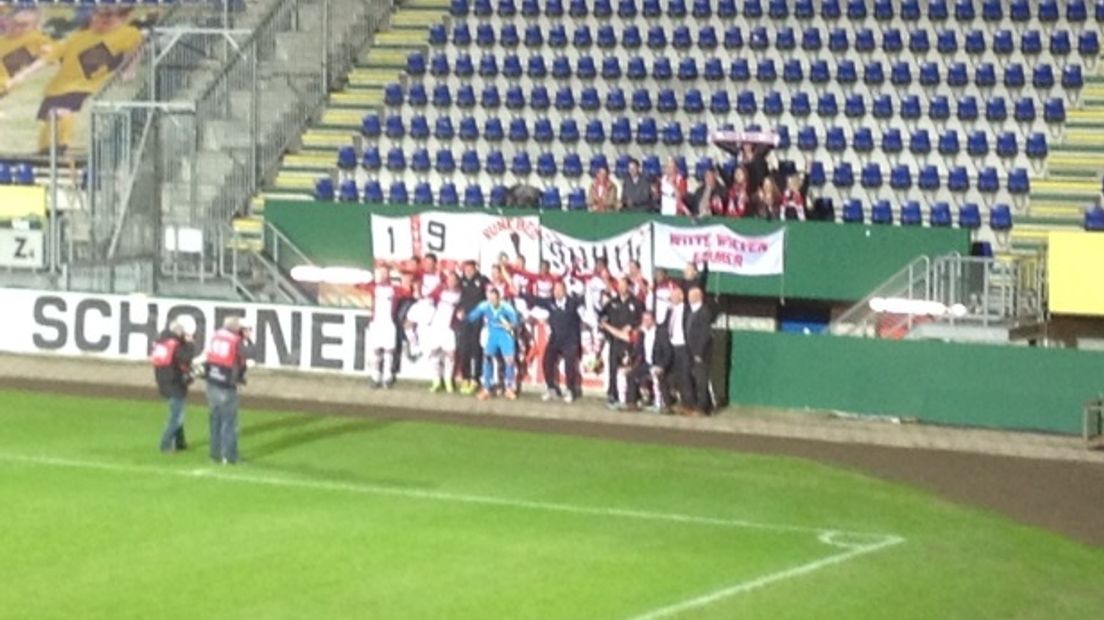 De spelers van FC Emmen vieren de grootste zege ooit met de meegereisde supporters