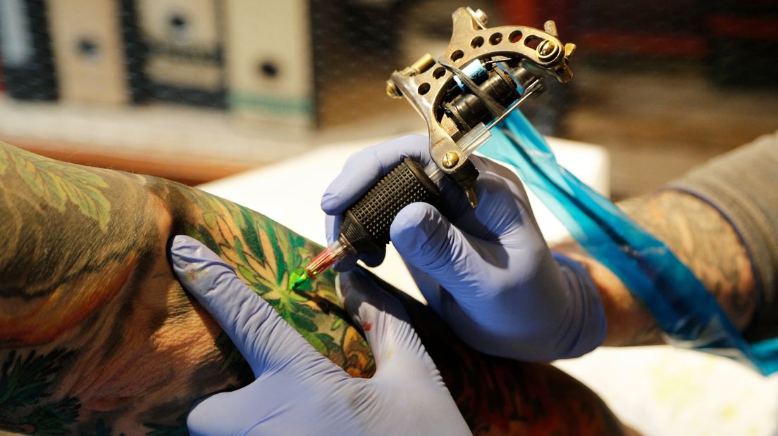 Een tatoeëerder aan het werk
