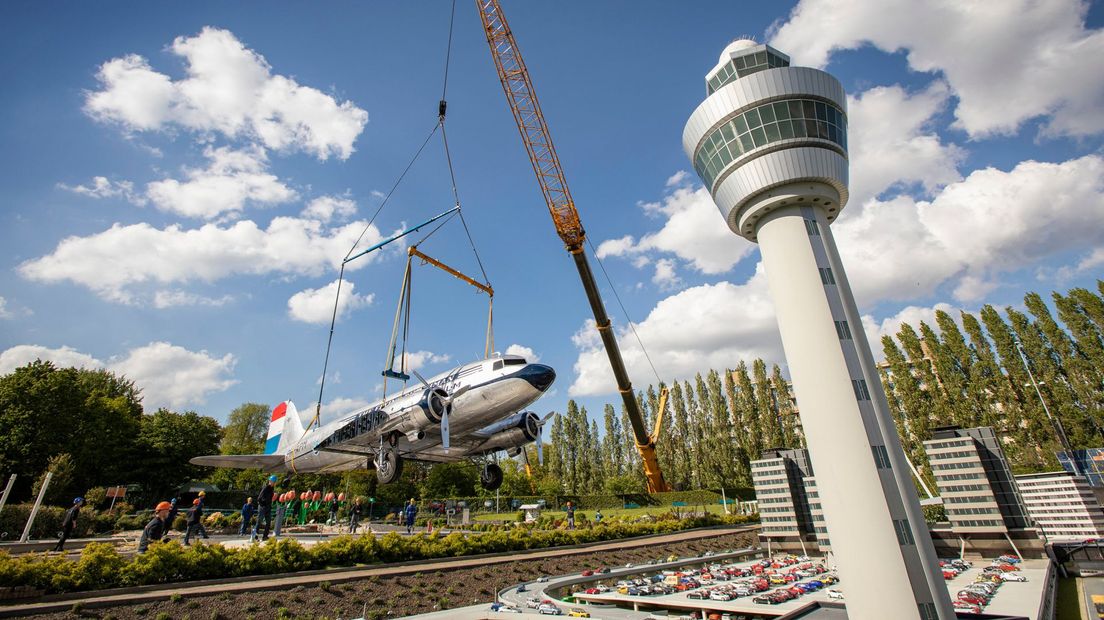 Het vliegtuig wordt met een hijskraan naast de Madurodam-versie van Schiphol gezet.