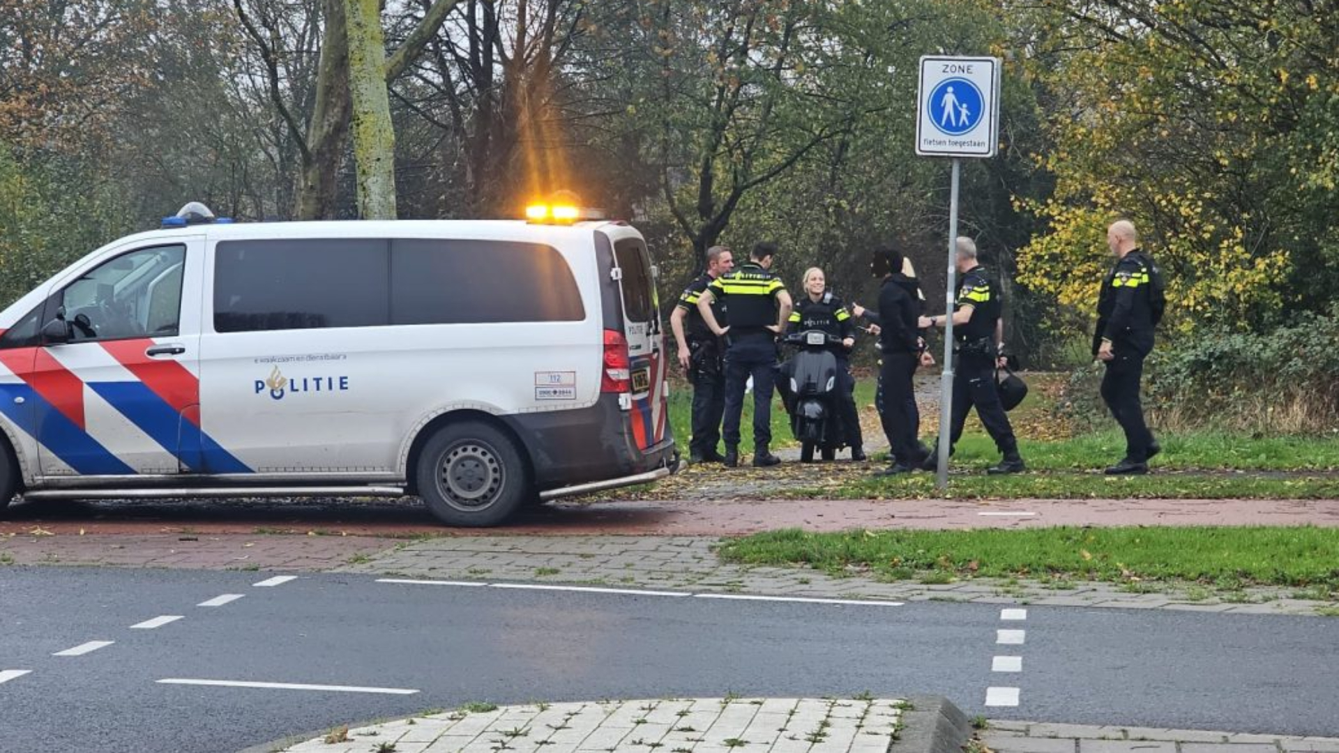 De politie met een van de aangehouden verdachten.