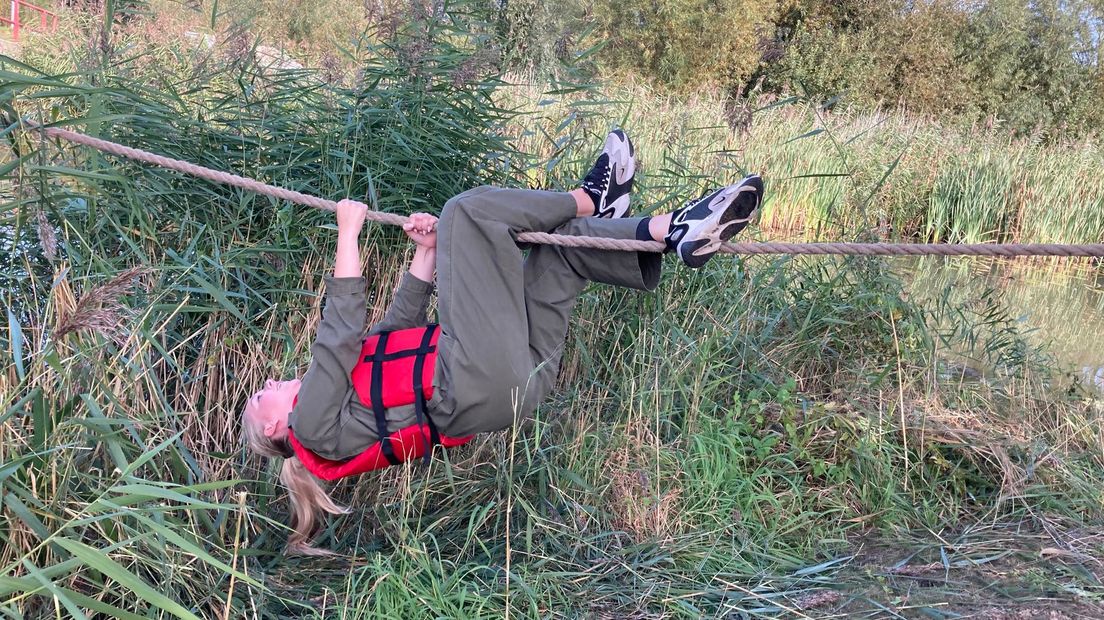 Deelnemers proberen met een touw over het water te klauteren. "Het is wel een paar keer misgegaan."