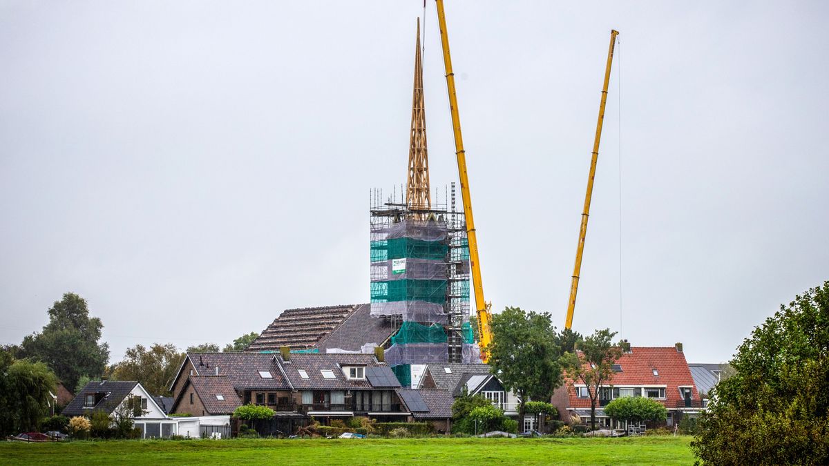 Enorme kranen hijsen nieuwe torenspits op eerder afgebrande kerk