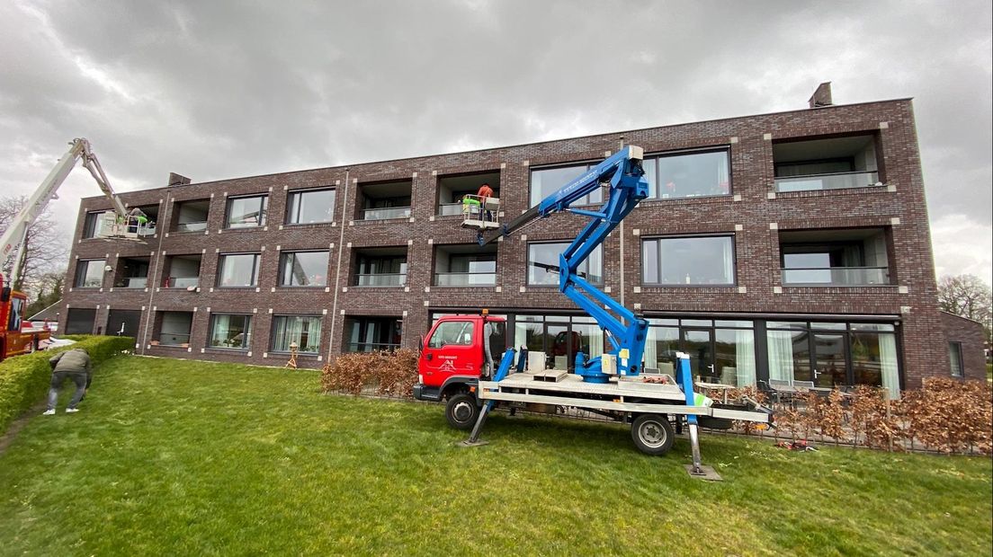 Via een hoogwerker familie in het zorgcomplex bezoeken