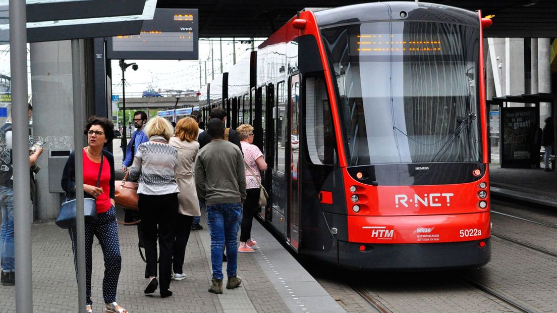 Passagiers stappen in de Avenio HTM-tram bij Den Haag Centraal 