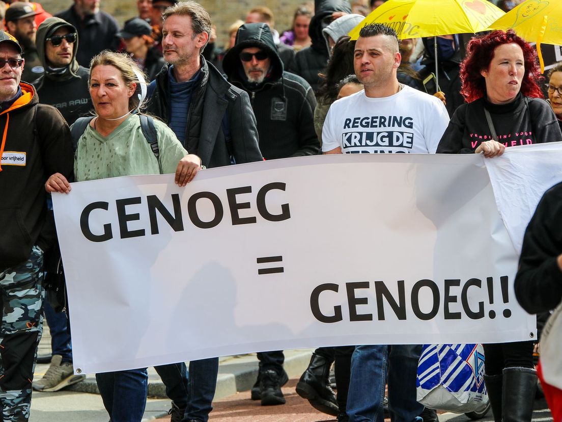 Demonstranten protesteren tegen het coronabeleid met spandoeken als 'genoeg = genoeg'