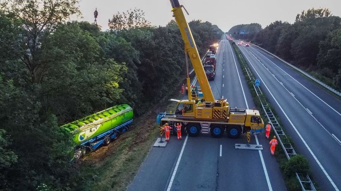 De vrachtwagen wordt overeind geholpen.