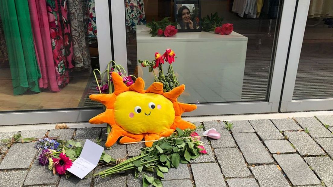 Voor de vestiging van Takko Fashion in Geldermalsen liggen bloemen. Binnen liggen bloemen bij een foto.