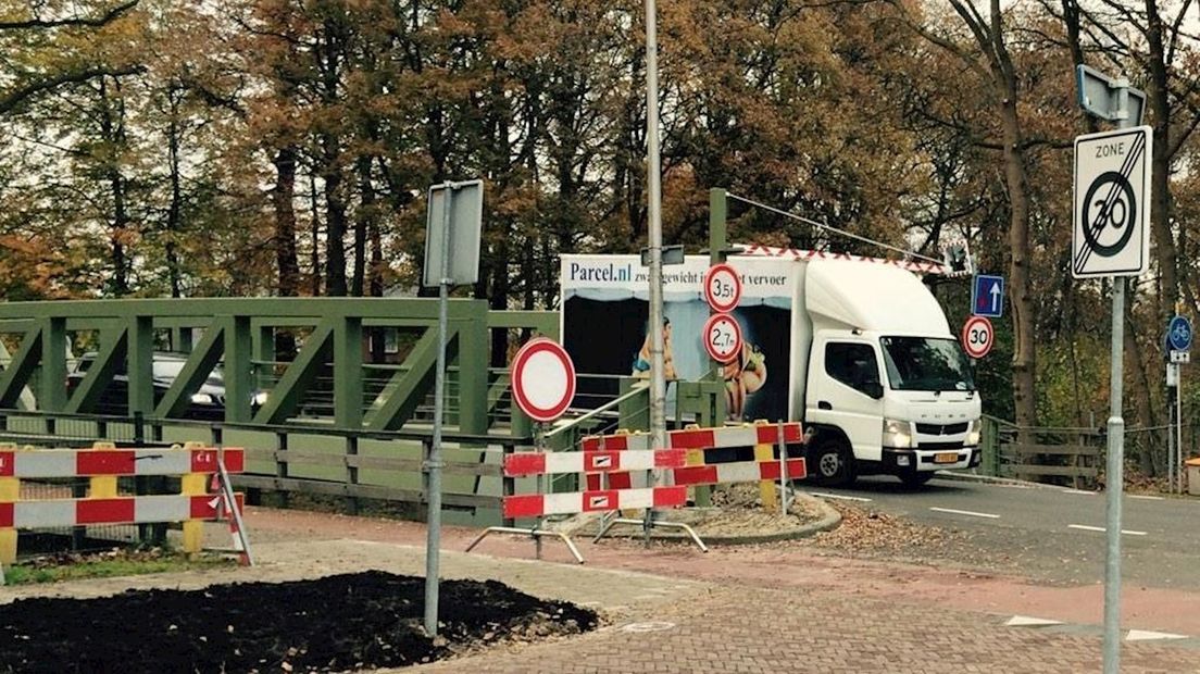 Busje rijdt hoogtebalken stuk op spoorbrug