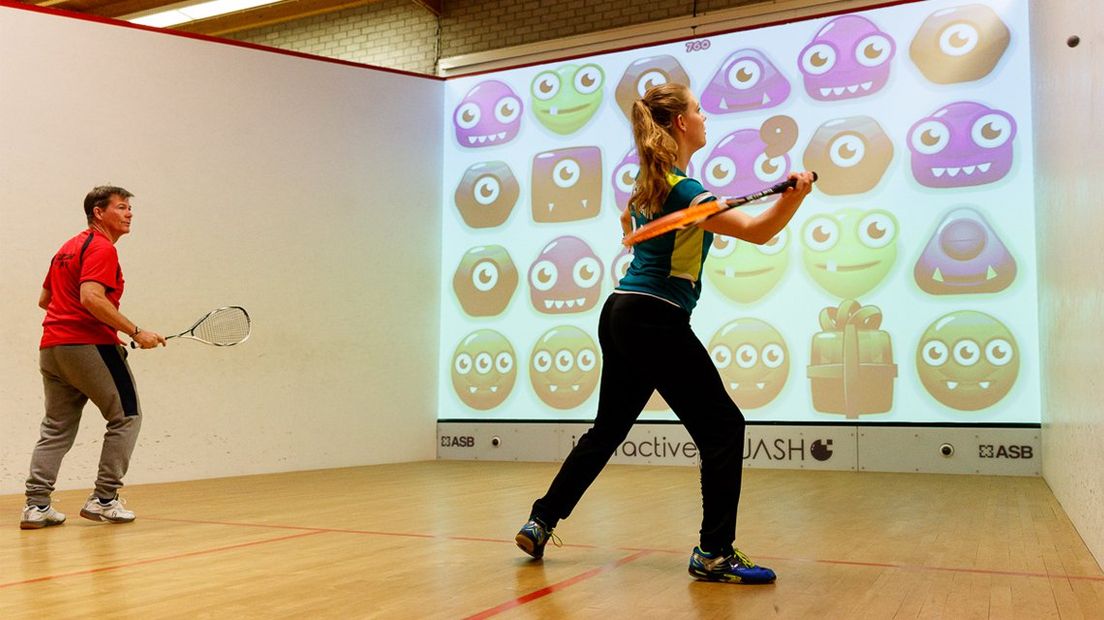 Sanne Veldkamp (rechts) en Ken Flynn testen de interactieve squashbaan. 