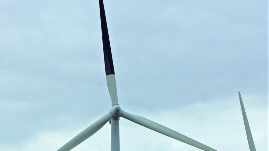 Een windmolen met een zwarte wiek