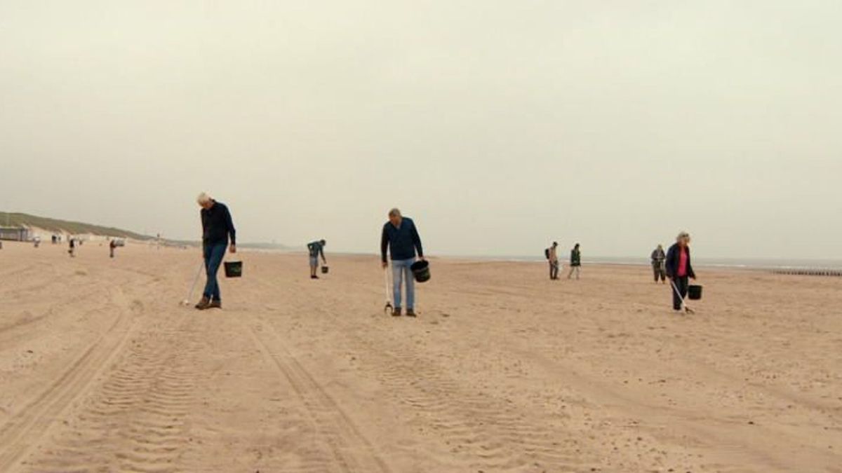 Vrijwilligers Het Groene Strand ruimen met de hand het strand op