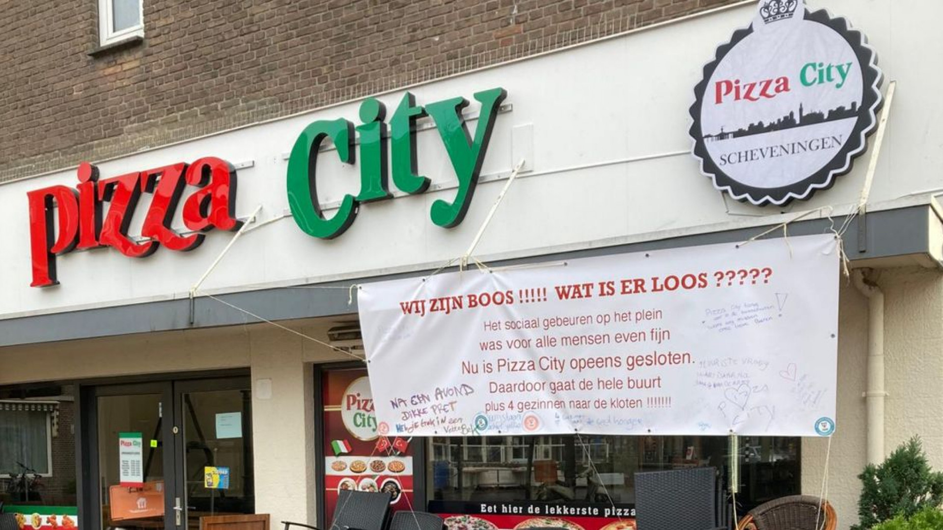 Het spandoek dat bij Pizza City hangt