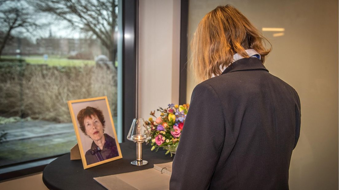Een medewerkster tekent het condoleanceregister ter nagedachtenis aan de verongelukte oud-collega.