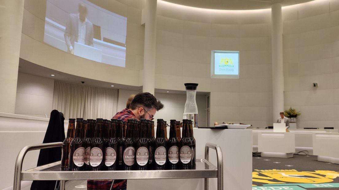 De Haagse gemeenteraad bijeen. Wethouder Bredemeijer trakteert op een biertje. | Foto Omroep West