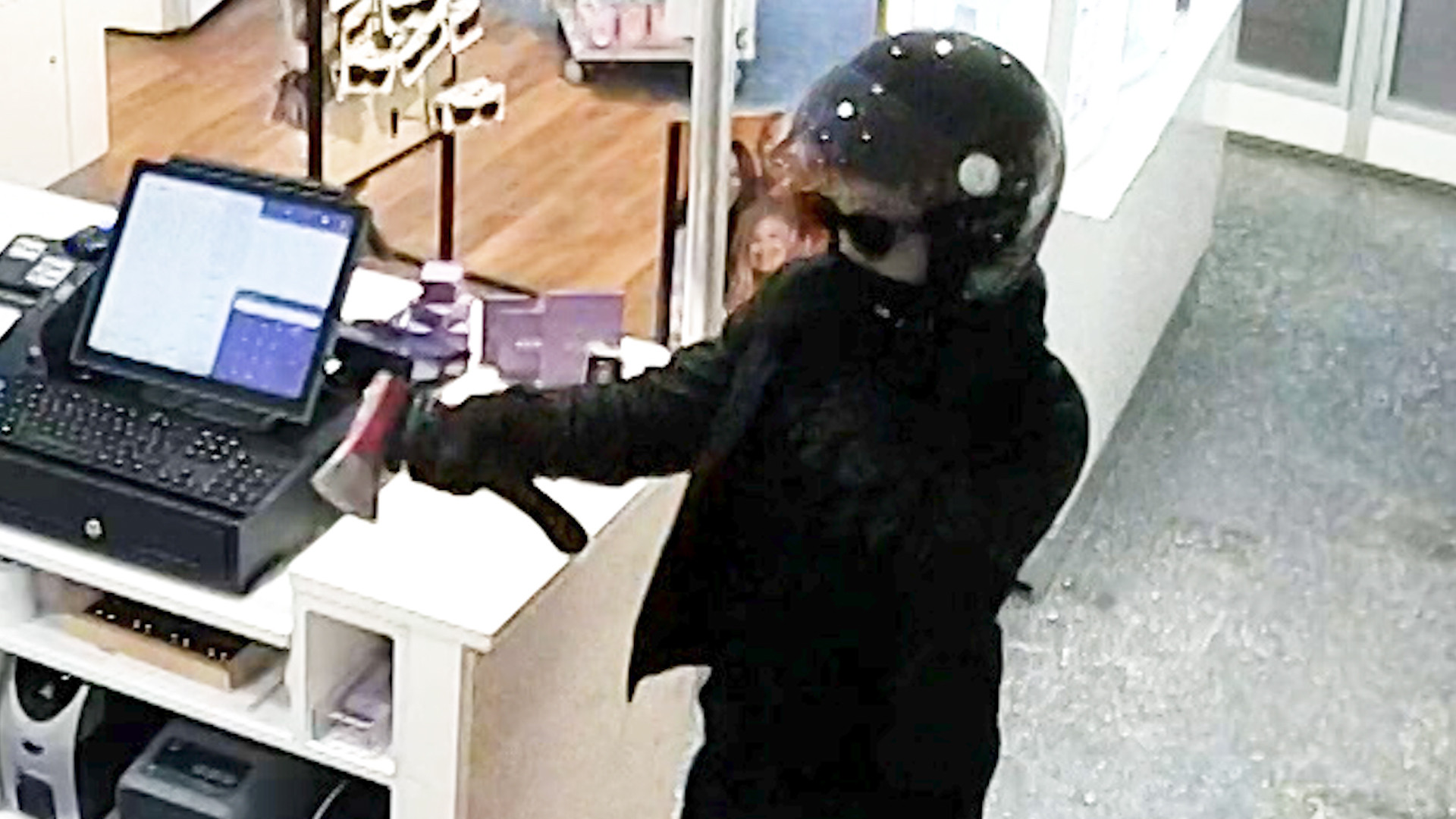 De overvaller dreigt met een hakbijl