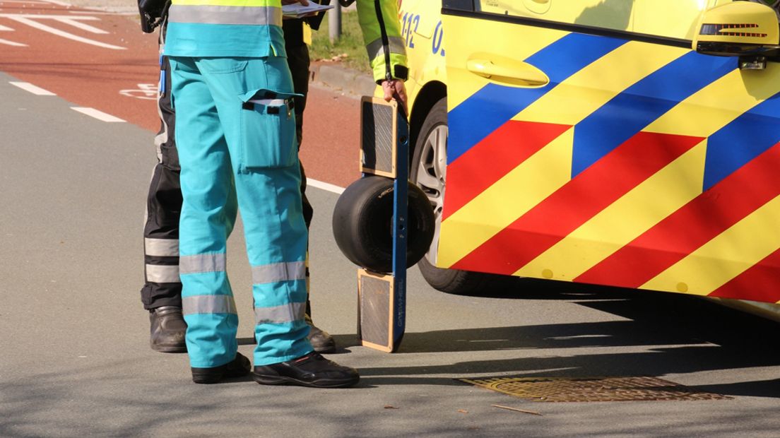 Medewerkers van de hulpdiensten halen de One Wheel van de weg.