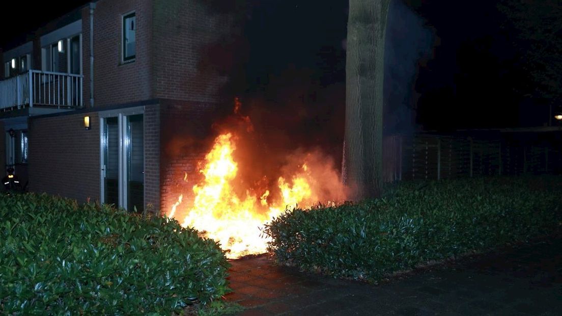 Container naast huizen in brand gestoken