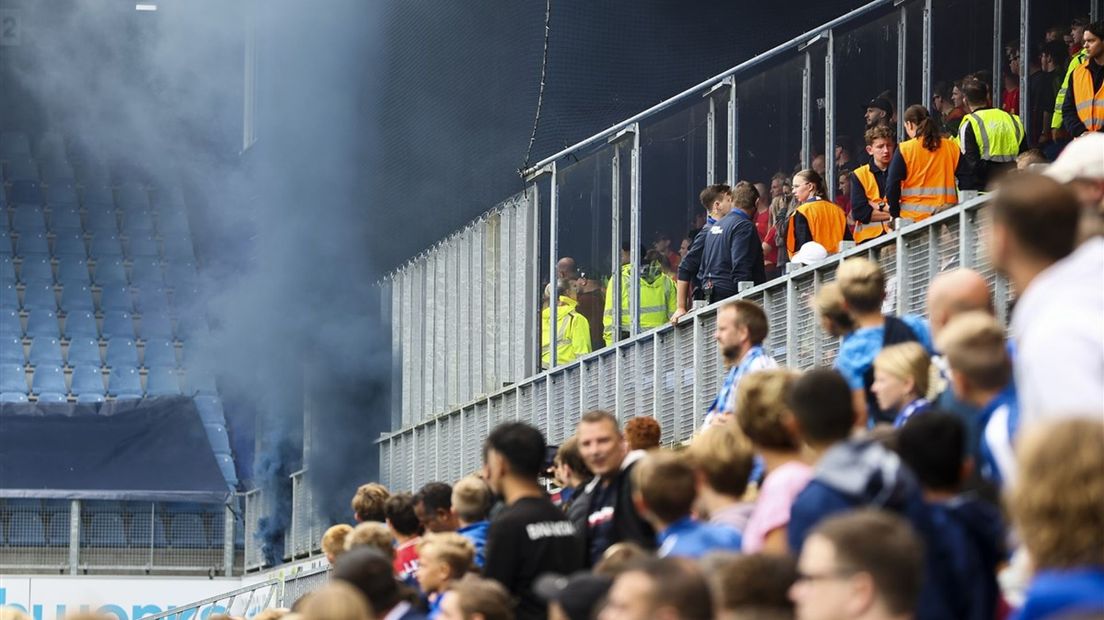 Een onwerkelijk beeld; blauwe rook uit het vak met Eagles-fans