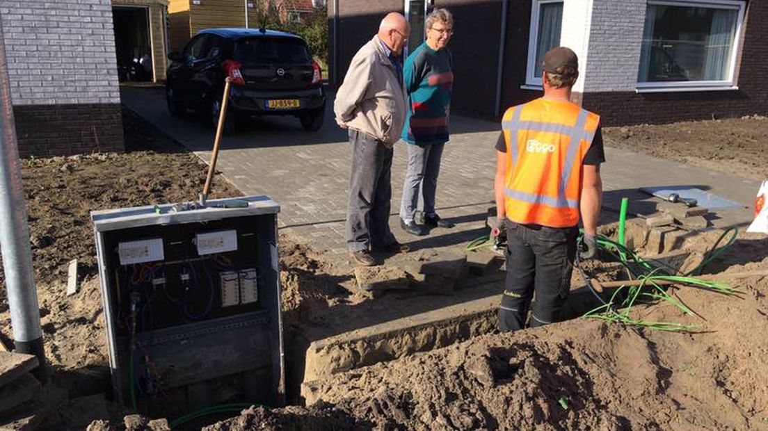 Aaldrik Stoppels en Gré Weerd kijken toe hoe een kabelkastje wordt weggehaald