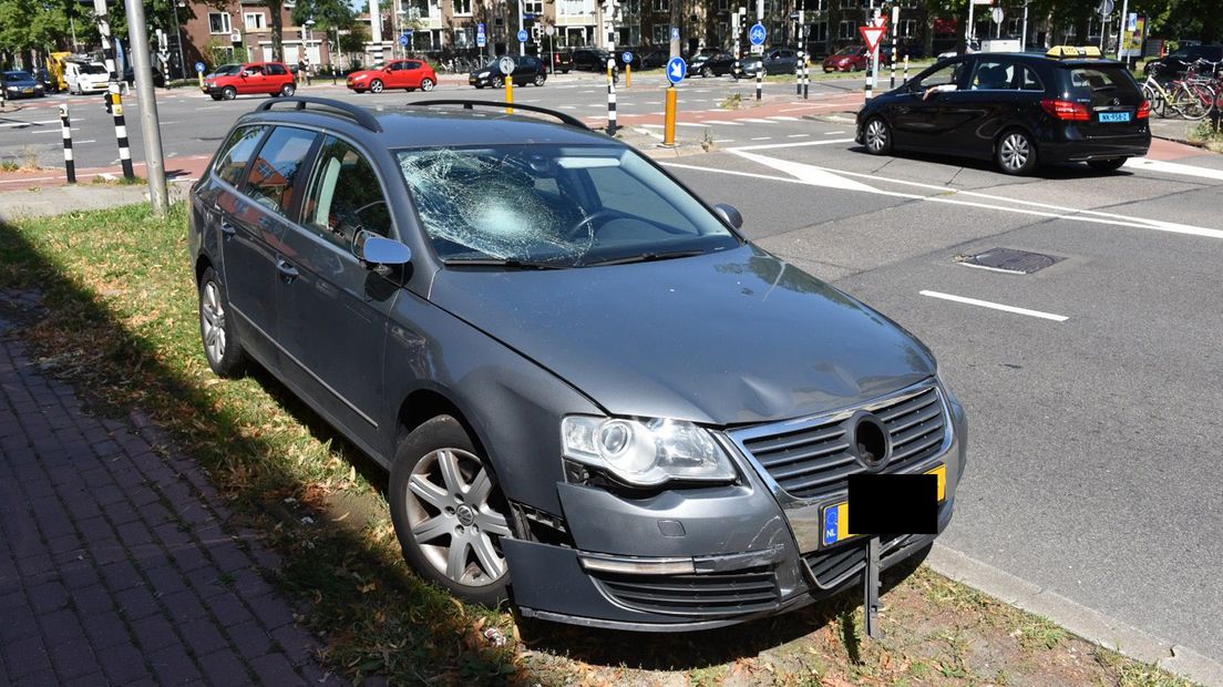 In de voorruit van de auto zit een flinke barst.