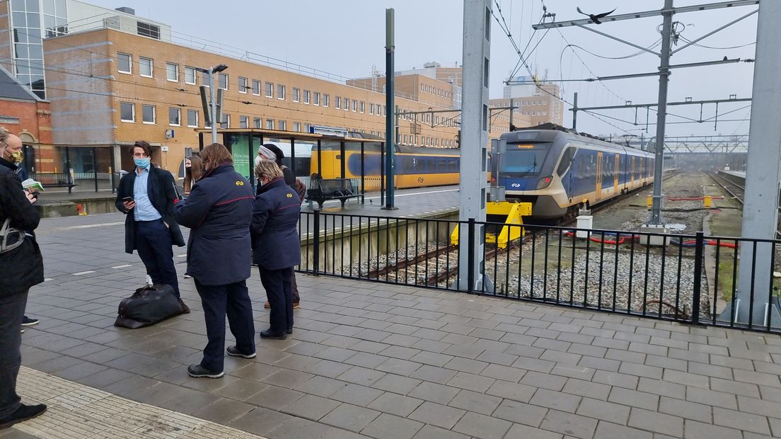 Treinpersoneel voert overleg op het station in Groningen