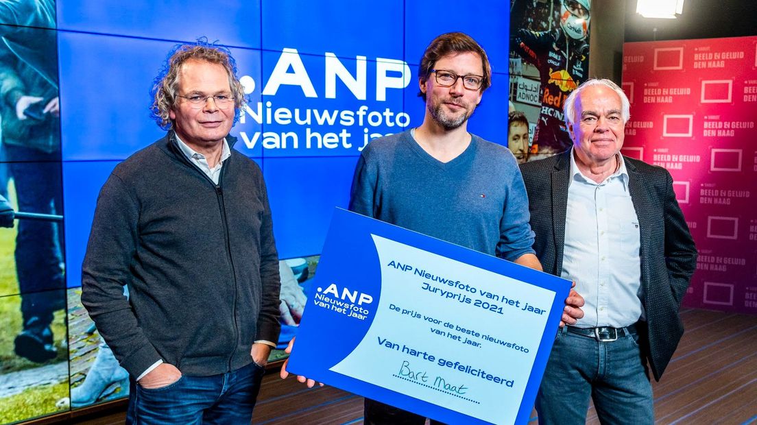 Fotograaf Bart Maat wint de ANP Nieuwsfoto van het jaar 2021. Presentator Edouard van Arem (l) en juryvoorzitter Leo Blom staan naast hem.