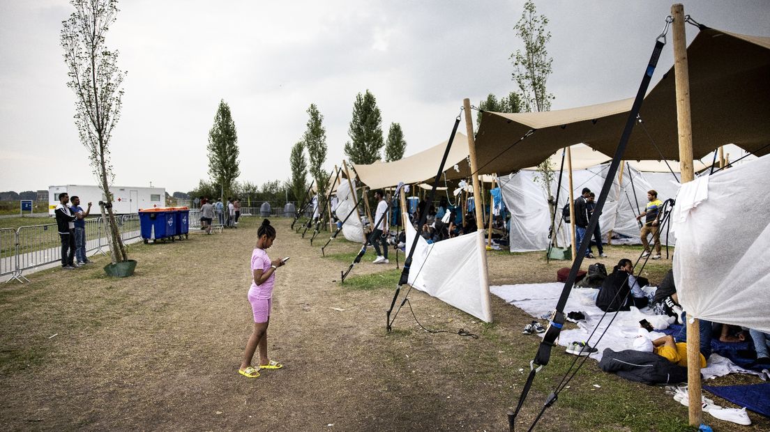 Asielzoekers bij het aanmeldcentrum, waar afgelopen zomer tenten werden geplaatst voor buitenslapers