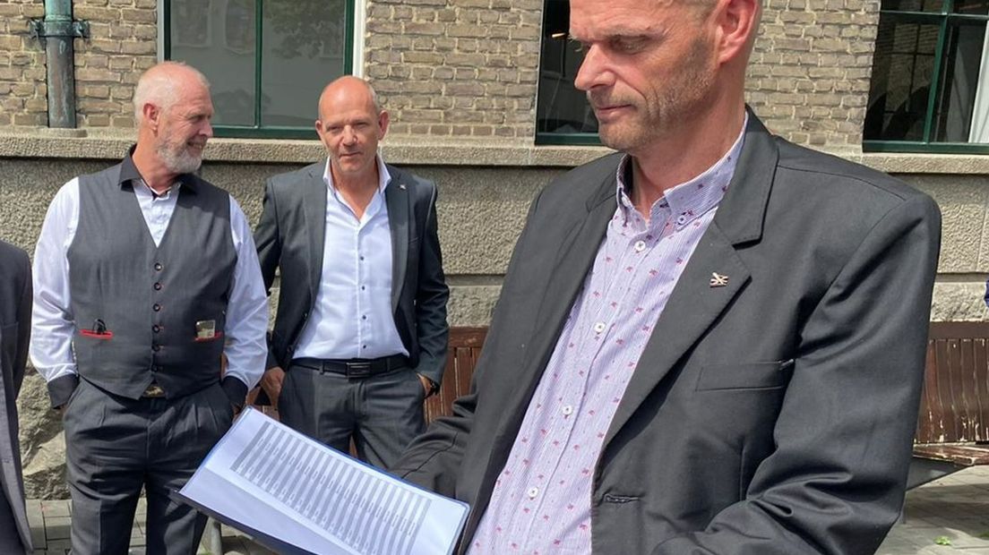 Gert Kel (BBE) neemt namens de gemeenteraad van Enschede handtekeningen in ontvangst van omwonenden van de Van Lochemstraat.