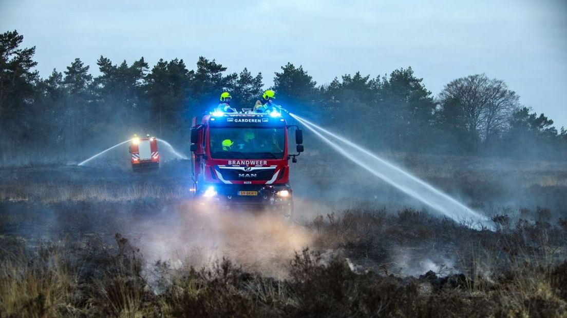 Brandweer blust het vuur op de heide in Uddel.