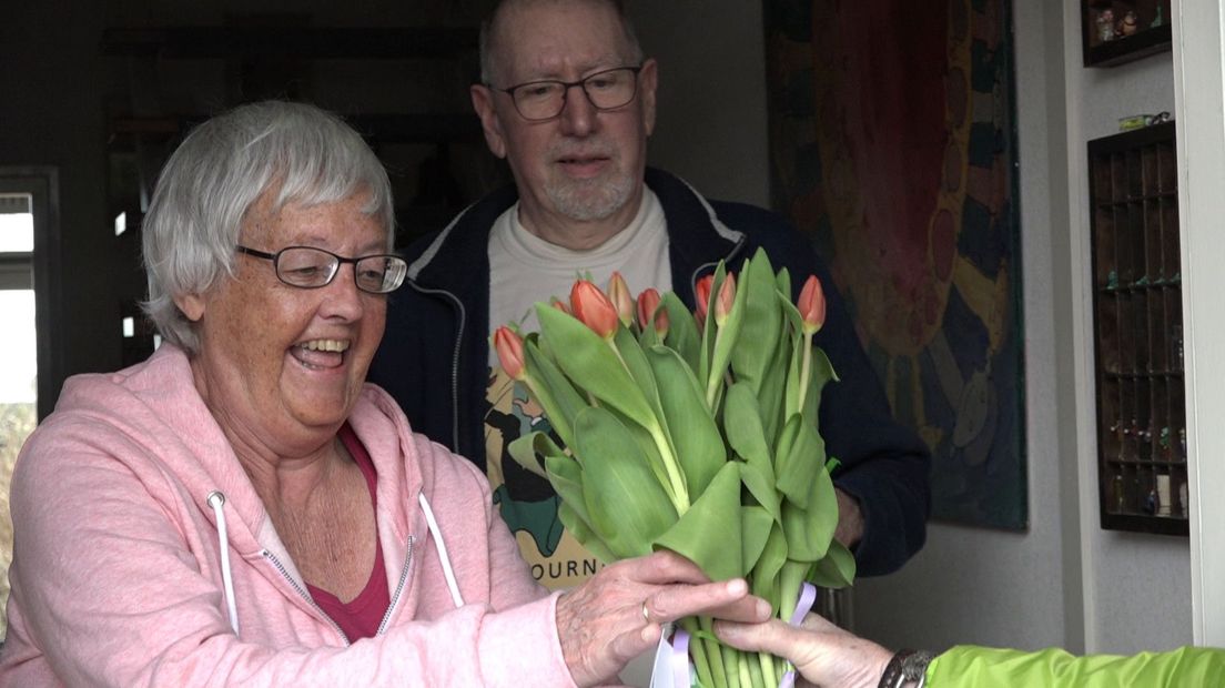 Het bosje tulpen wordt overhandigd